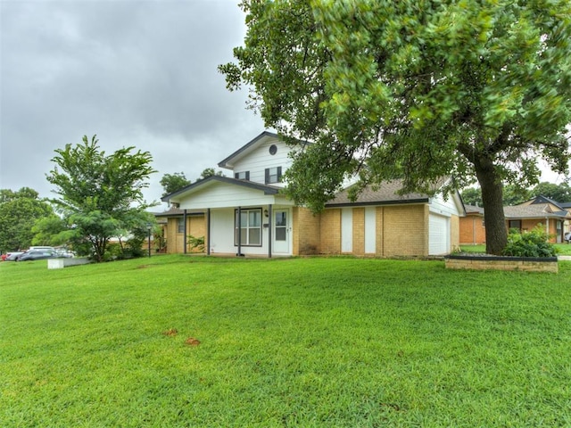 4113 Clendon Way, Del City, OK 73115 - view of front of property with a garage, a front lawn, brick siding, and a porch