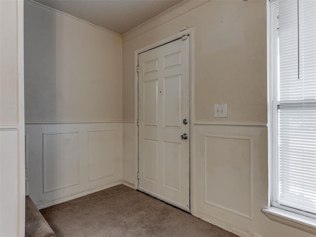 4113 Clendon Way, Del City, OK 73115 - entryway with a decorative wall, crown molding, carpet flooring, a wainscoted wall, and a textured ceiling