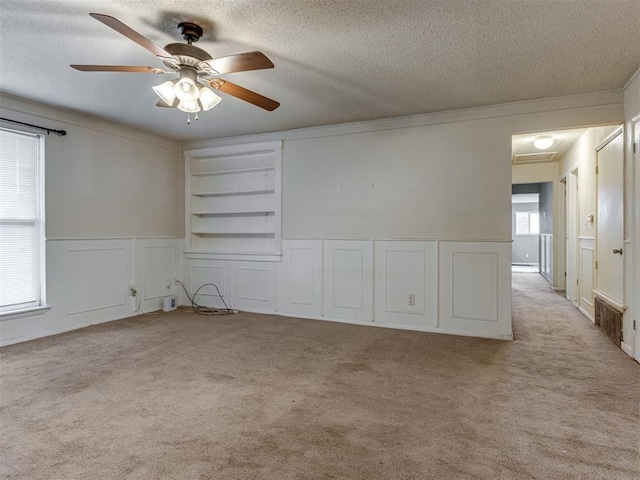 4113 Clendon Way, Del City, OK 73115 - spare room with a textured ceiling, carpet flooring, ceiling fan, ornamental molding, and built in features