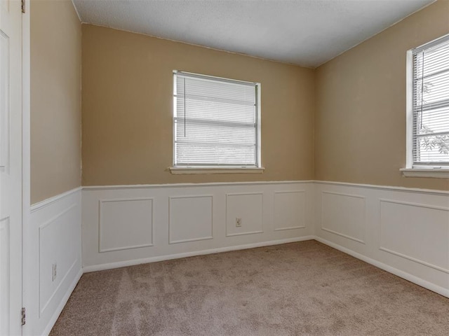 4113 Clendon Way, Del City, OK 73115 - carpeted spare room with plenty of natural light, a wainscoted wall, and a decorative wall
