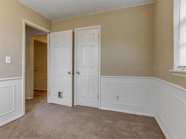 4113 Clendon Way, Del City, OK 73115 - unfurnished bedroom with wainscoting, carpet, a closet, and a textured ceiling