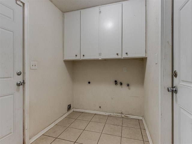 4113 Clendon Way, Del City, OK 73115 - laundry area featuring electric dryer hookup, cabinet space, and light tile patterned flooring