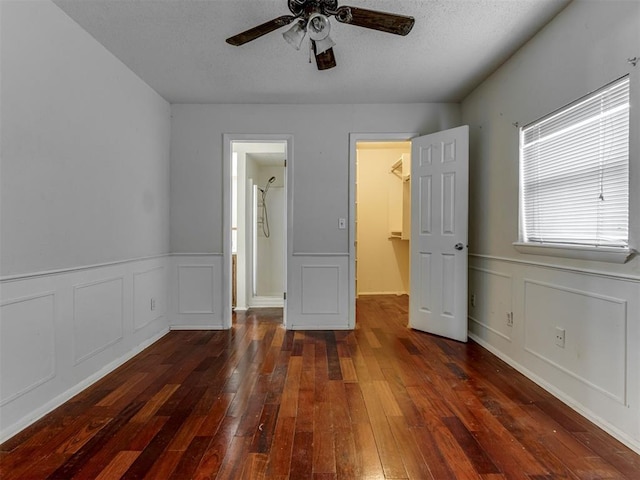 4113 Clendon Way, Del City, OK 73115 - unfurnished bedroom featuring a decorative wall, hardwood / wood-style floors, a spacious closet, wainscoting, and a ceiling fan