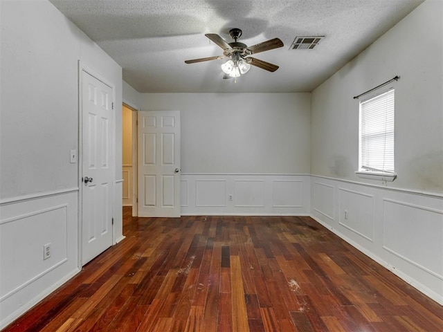 4113 Clendon Way, Del City, OK 73115 - empty room featuring hardwood / wood-style floors, ceiling fan, wainscoting, a textured ceiling, and a decorative wall