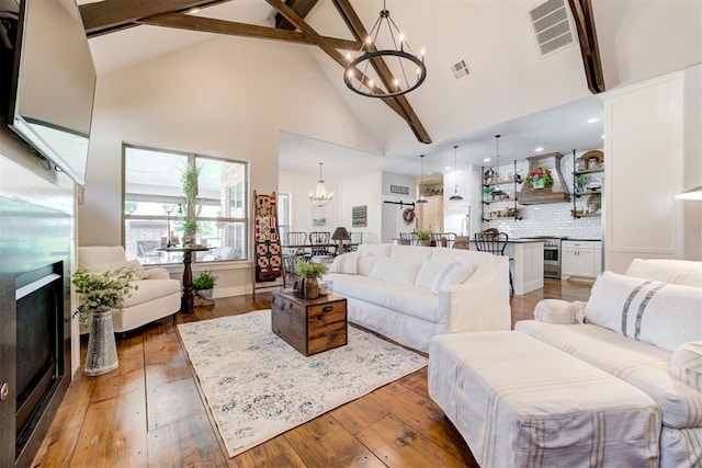 209 Pont Julienn Ct, Edmond, OK 73034 - living area with a chandelier, high vaulted ceiling, light wood-style flooring, beamed ceiling, and a fireplace