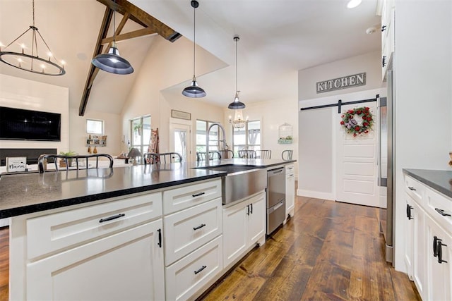 209 Pont Julienn Ct, Edmond, OK 73034 - kitchen featuring a chandelier, stainless steel dishwasher, dark wood finished floors, a barn door, and white cabinets