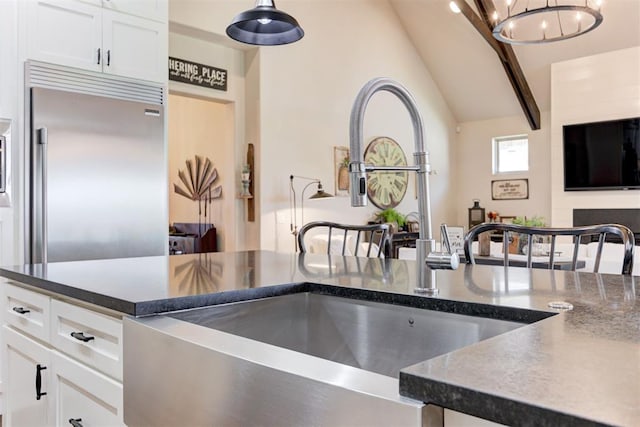 209 Pont Julienn Ct, Edmond, OK 73034 - kitchen with stainless steel built in refrigerator, white cabinets, a chandelier, decorative light fixtures, and dark stone countertops