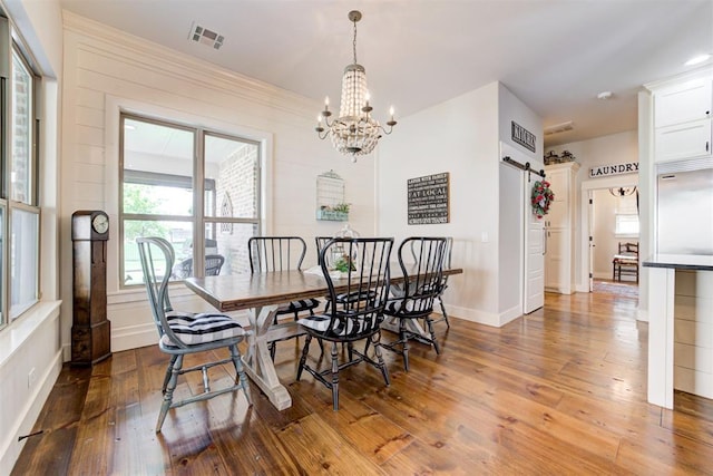 209 Pont Julienn Ct, Edmond, OK 73034 - dining room featuring a barn door, a chandelier, and hardwood / wood-style flooring