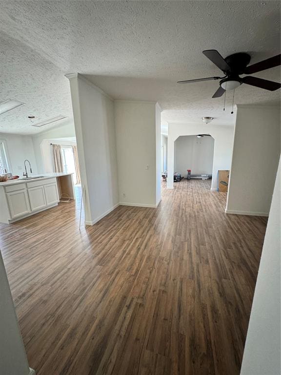 2099 County Road 1244, Tuttle, OK 73089 - unfurnished living room featuring a textured ceiling, wood finished floors, a ceiling fan, and healthy amount of natural light