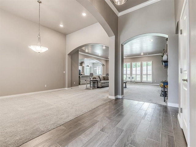 210 Bulverde Dr, Norman, OK 73069 - carpeted spare room featuring ornamental molding, arched walkways, wood finish floors, and recessed lighting