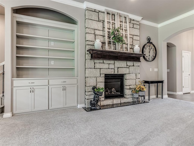 210 Bulverde Dr, Norman, OK 73069 - living room featuring carpet, ornamental molding, arched walkways, a fireplace, and built in features