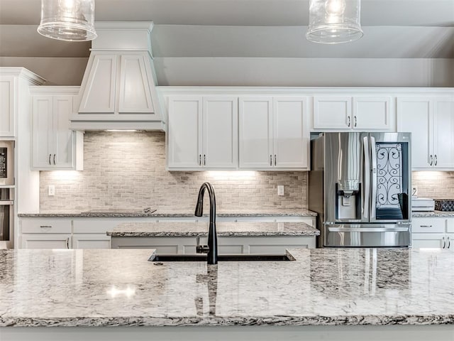 210 Bulverde Dr, Norman, OK 73069 - kitchen featuring appliances with stainless steel finishes, white cabinetry, backsplash, light stone counters, and decorative light fixtures