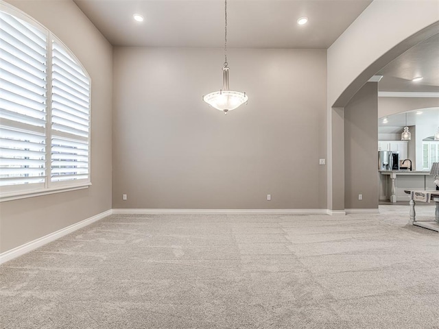 210 Bulverde Dr, Norman, OK 73069 - empty room featuring light colored carpet, arched walkways, and recessed lighting