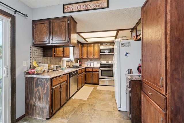 809 N Southminster St, Moore, OK 73160 - kitchen featuring stainless steel appliances, tasteful backsplash, light countertops, stone finish flooring, and a textured ceiling