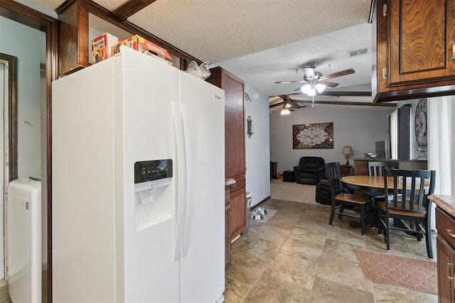 809 N Southminster St, Moore, OK 73160 - kitchen featuring white fridge with ice dispenser, ceiling fan, light stone finish flooring, a textured ceiling, and light countertops
