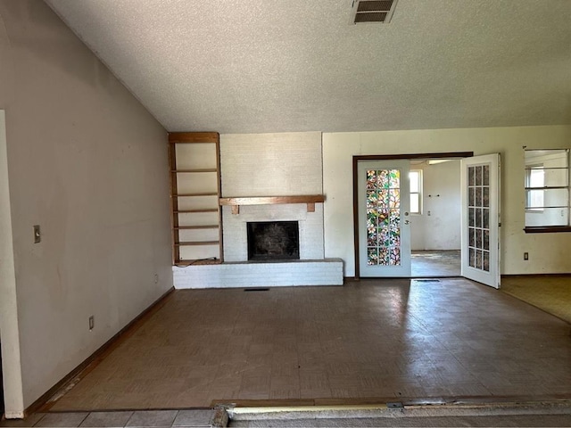 1408 NW 107th St, Oklahoma City, OK 73114 - unfurnished living room featuring a textured ceiling and a brick fireplace