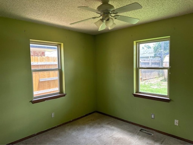 1408 NW 107th St, Oklahoma City, OK 73114 - carpeted empty room with healthy amount of natural light, a ceiling fan, and a textured ceiling