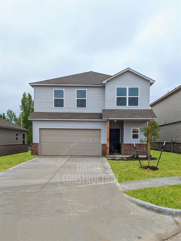 3629 Pete St, Yukon, OK 73064 - view of front of home with an attached garage, driveway, brick siding, a front lawn, and a shingled roof