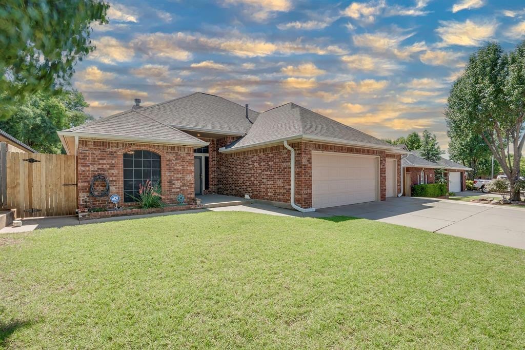 12908 Jaymel Ln, Oklahoma City, OK 73170 - view of front of home featuring a garage, roof with shingles, brick siding, and driveway