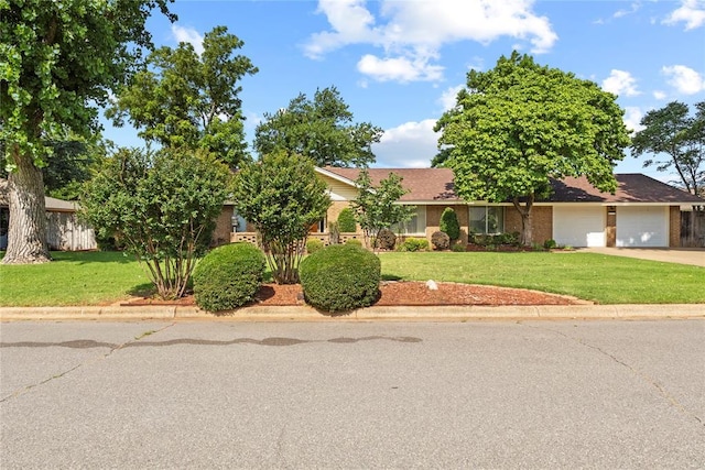 717 Maple St, Weatherford, OK 73096 - view of front of house with concrete driveway, a front yard, a garage, and brick siding