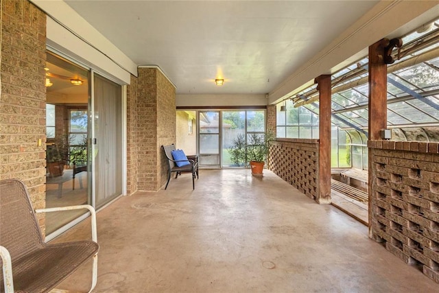 717 Maple St, Weatherford, OK 73096 - unfurnished sunroom with concrete floors and brick wall