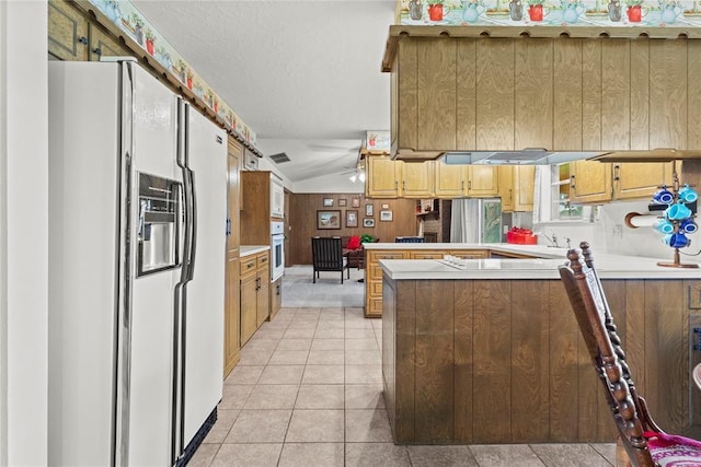 717 Maple St, Weatherford, OK 73096 - kitchen with white appliances, a peninsula, light tile patterned flooring, light countertops, and lofted ceiling