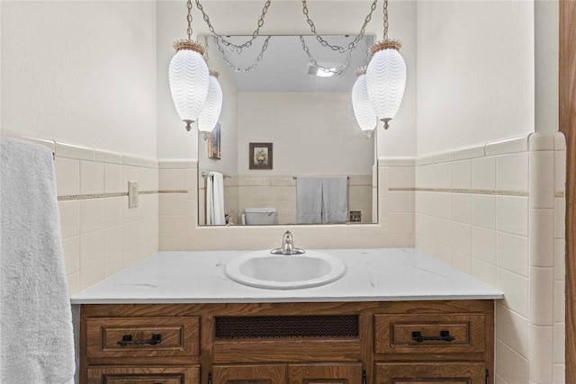 717 Maple St, Weatherford, OK 73096 - bathroom featuring vanity, tile walls, and wainscoting