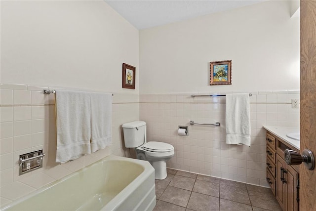 717 Maple St, Weatherford, OK 73096 - bathroom featuring a garden tub, vanity, tile patterned flooring, tile walls, and wainscoting