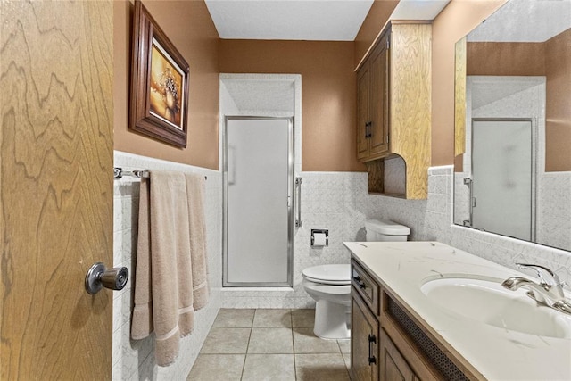 717 Maple St, Weatherford, OK 73096 - bathroom with a stall shower, vanity, tile patterned flooring, wainscoting, and tile walls