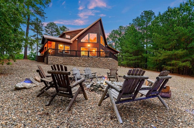 232 Orange Grove Rd, Broken Bow, OK 74728 - rear view of house featuring log veneer siding, a fire pit, and a metal roof