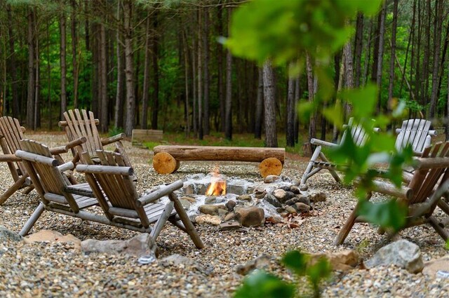 232 Orange Grove Rd, Broken Bow, OK 74728 - view of patio featuring a fire pit and a forest view