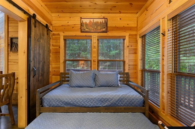 232 Orange Grove Rd, Broken Bow, OK 74728 - bedroom featuring wood walls and a barn door