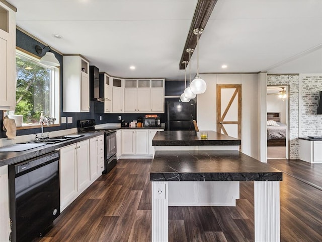 kitchen featuring black appliances, wall chimney range hood, dark countertops, a kitchen island, and dark wood-style flooring