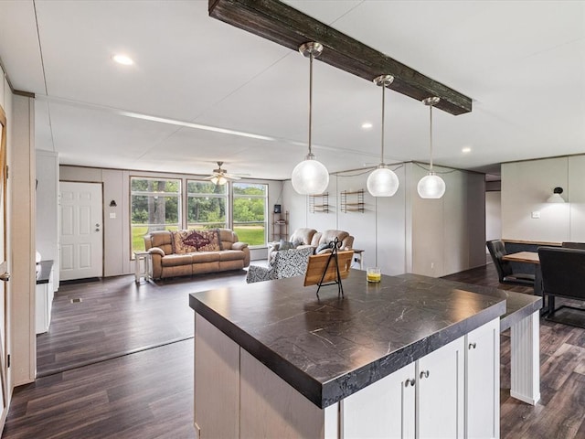 kitchen with dark countertops, open floor plan, dark wood-type flooring, and recessed lighting