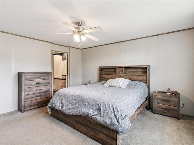 bedroom featuring light colored carpet, ceiling fan, and connected bathroom
