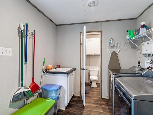 laundry area with washer and dryer, dark wood finished floors, ornamental molding, and cabinet space
