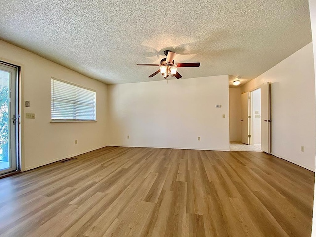 223 E Lincoln Ave, Edmond, OK 73034 - unfurnished living room with ceiling fan, light wood finished floors, and a textured ceiling