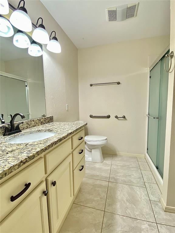223 E Lincoln Ave, Edmond, OK 73034 - full bath featuring vanity, a stall shower, and tile patterned flooring