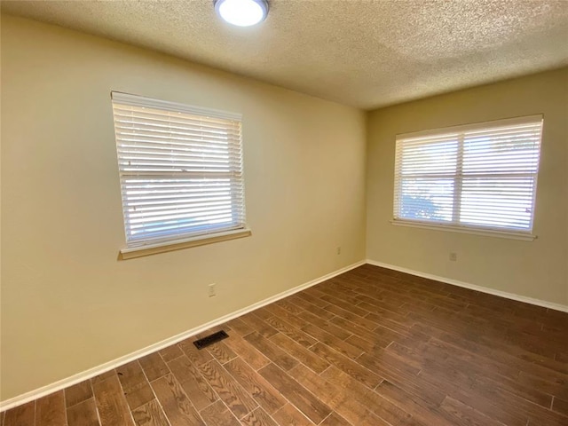 223 E Lincoln Ave, Edmond, OK 73034 - unfurnished room featuring a textured ceiling, healthy amount of natural light, and dark wood-style floors