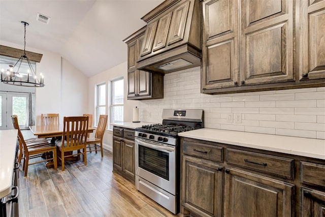 2408 NW 179th St, Edmond, OK 73012 - kitchen with stainless steel range with gas cooktop, lofted ceiling, a chandelier, backsplash, and light wood-type flooring