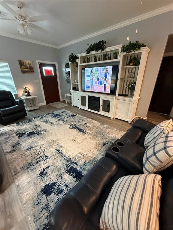 105967 S Rolling Hills Dr, Meeker, OK 74855 - living room with wood finished floors, ornamental molding, and ceiling fan
