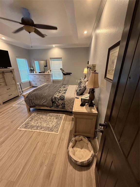 105967 S Rolling Hills Dr, Meeker, OK 74855 - bedroom featuring wood finished floors, a raised ceiling, ceiling fan, recessed lighting, and crown molding