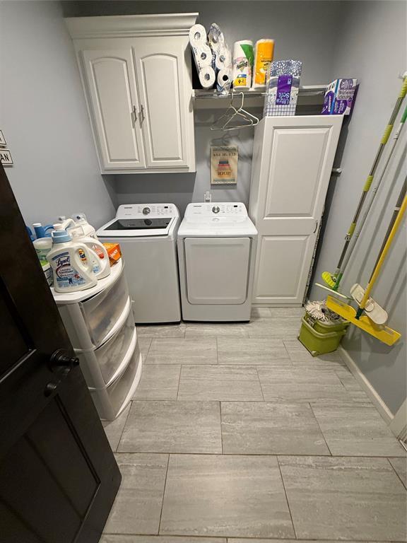 105967 S Rolling Hills Dr, Meeker, OK 74855 - washroom featuring washing machine and clothes dryer, wood tiled floors, and cabinet space