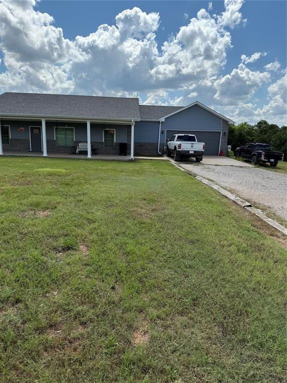 105967 S Rolling Hills Dr, Meeker, OK 74855 - ranch-style house with a front lawn, driveway, a garage, and a porch