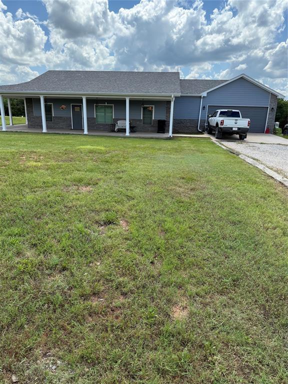105967 S Rolling Hills Dr, Meeker, OK 74855 - ranch-style house with covered porch, a front yard, and a garage