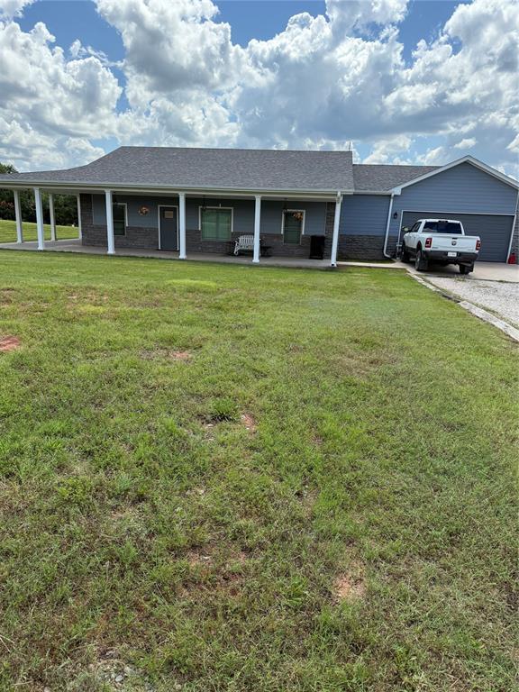 105967 S Rolling Hills Dr, Meeker, OK 74855 - ranch-style house with a front yard, an attached garage, and driveway