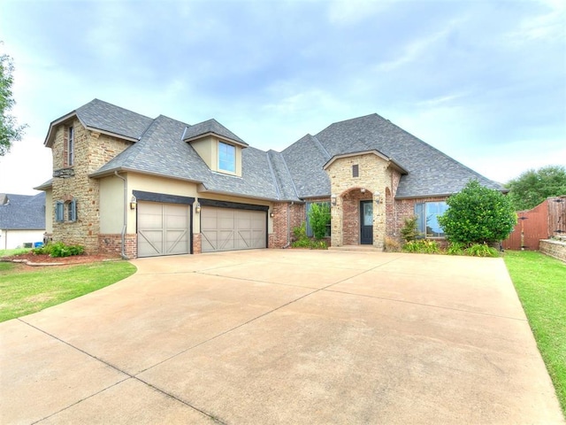 3009 Cordova Ct, Norman, OK 73072 - french country style house with driveway, a garage, roof with shingles, stucco siding, and brick siding
