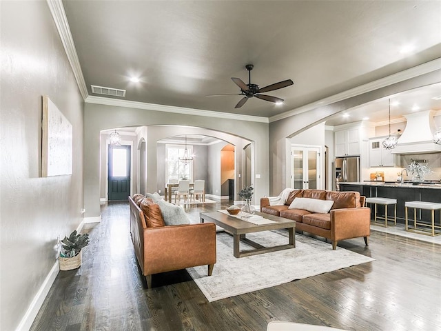 3009 Cordova Ct, Norman, OK 73072 - living room featuring arched walkways, a chandelier, dark wood-style flooring, ceiling fan, and ornamental molding