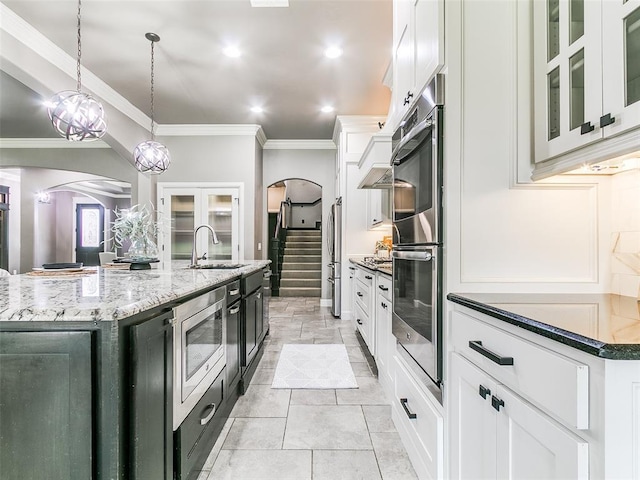 3009 Cordova Ct, Norman, OK 73072 - kitchen with arched walkways, appliances with stainless steel finishes, white cabinets, crown molding, and recessed lighting