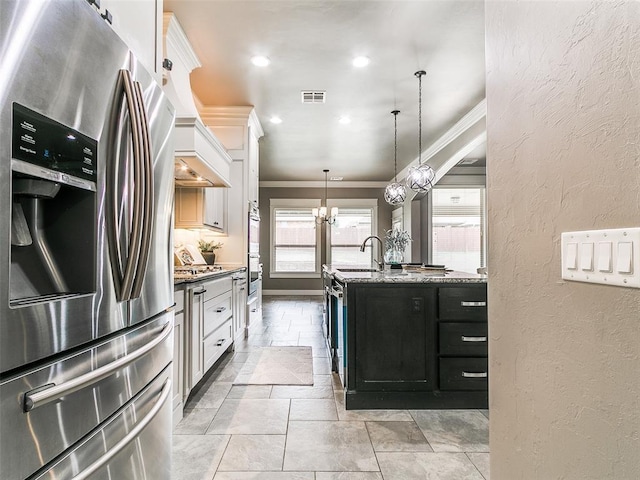 3009 Cordova Ct, Norman, OK 73072 - kitchen with stainless steel fridge, ornamental molding, a textured wall, stone tile flooring, and an island with sink